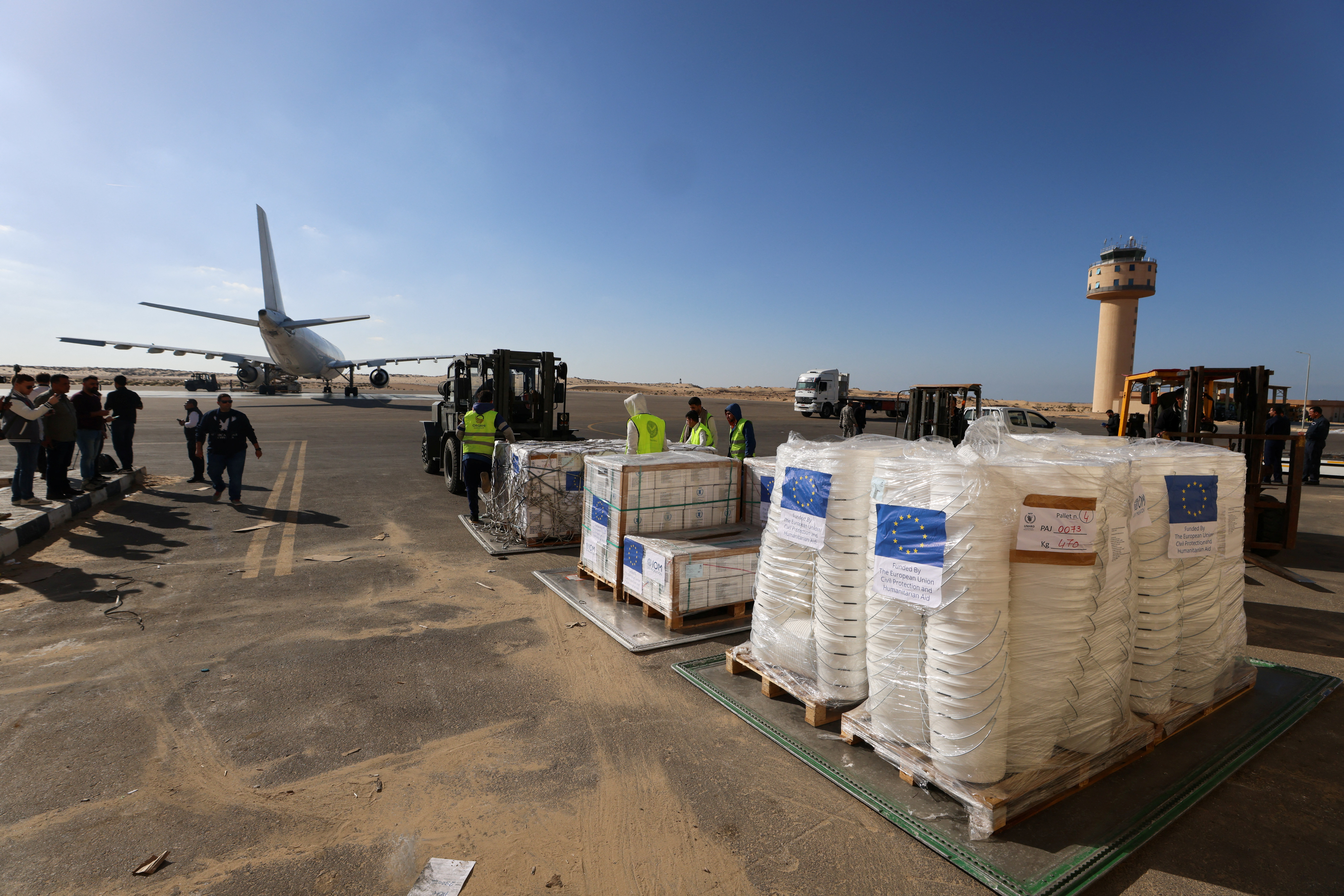 Workers unload humanitarian aid destined for the Gaza Strip via Rafah border area, at Al Arish airport
