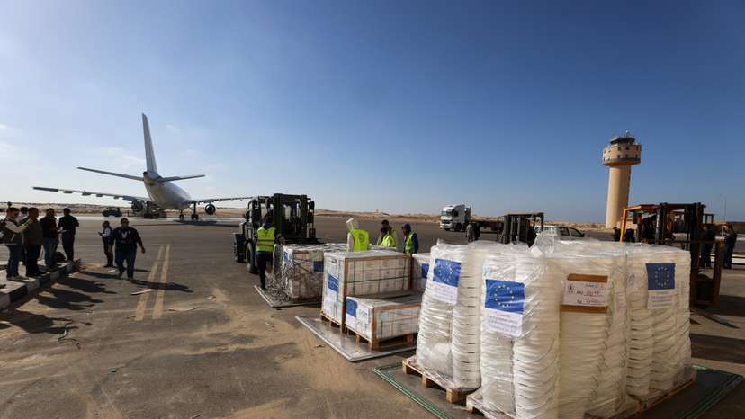 Workers unload humanitarian aid destined for the Gaza Strip via Rafah border area, at Al Arish airport