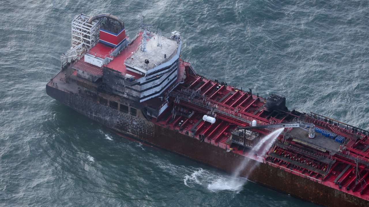 Aftermath of collision between container ship and oil tanker