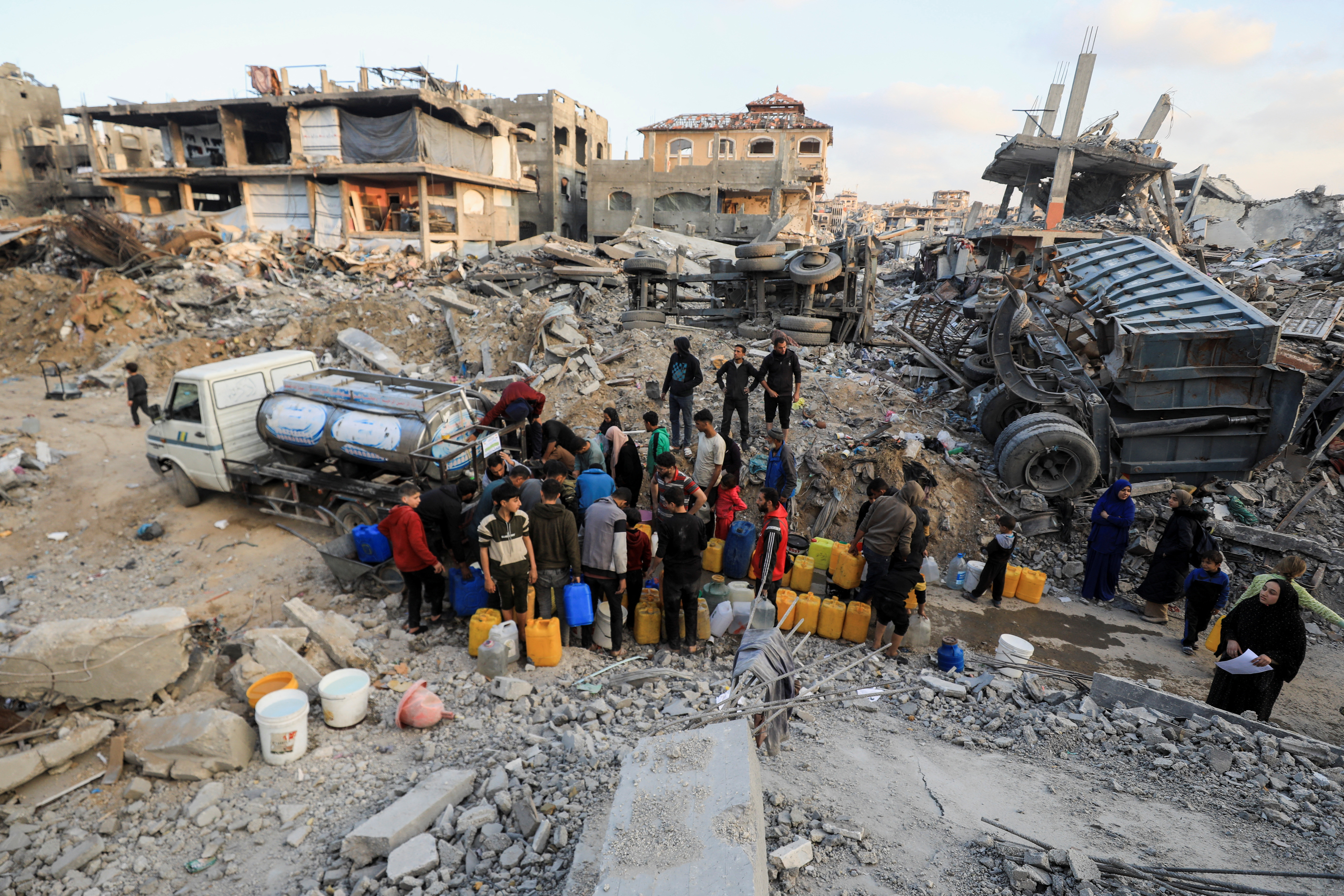 Palestinians fill up containers with water, in Jabalia refugee camp