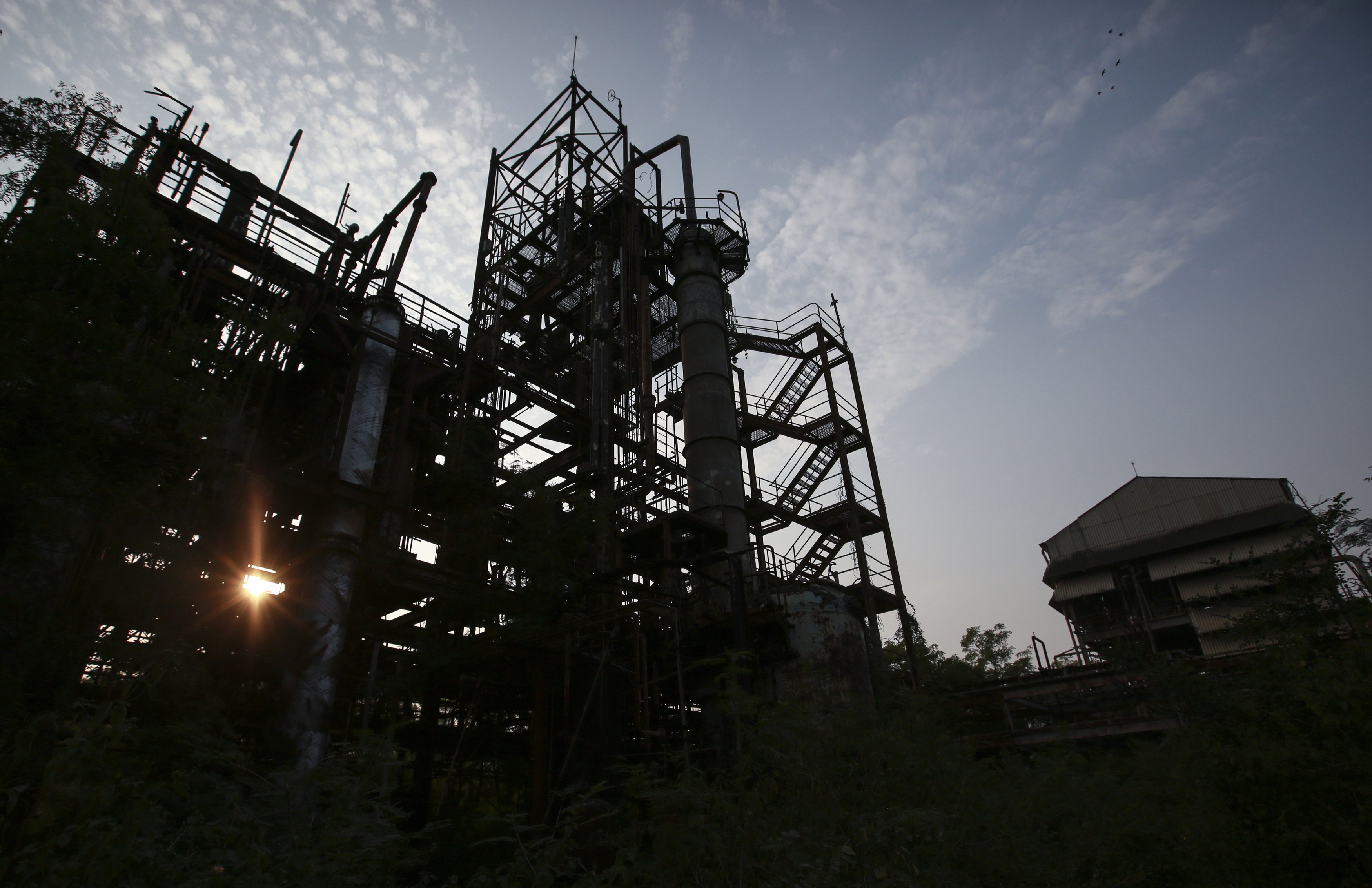 The sun sets behind the abandoned former Union Carbide pesticide plant in Bhopal