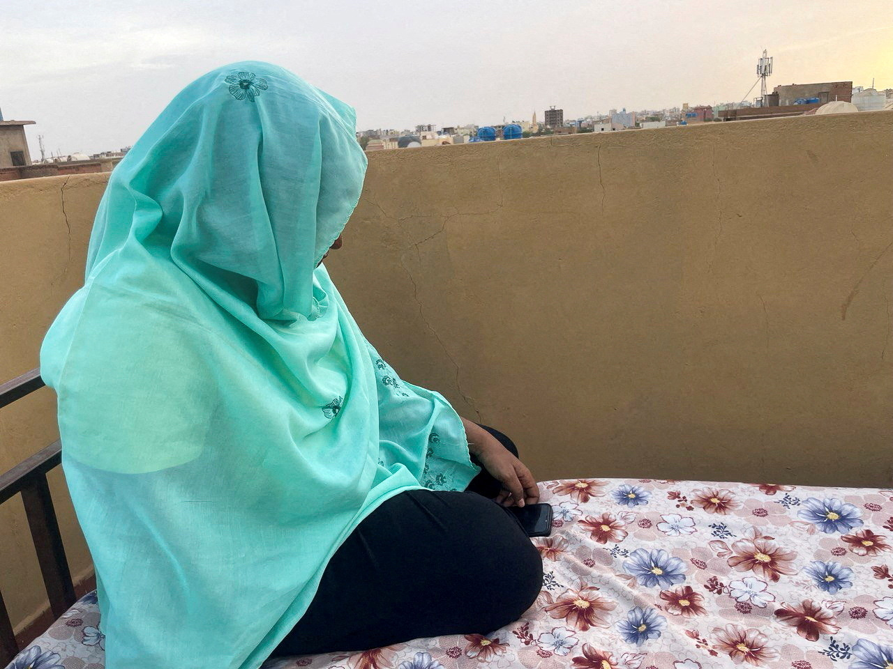 FILE PHOTO: Heba checks her phone for news of her relatives at her house during the conflict in Khartoum