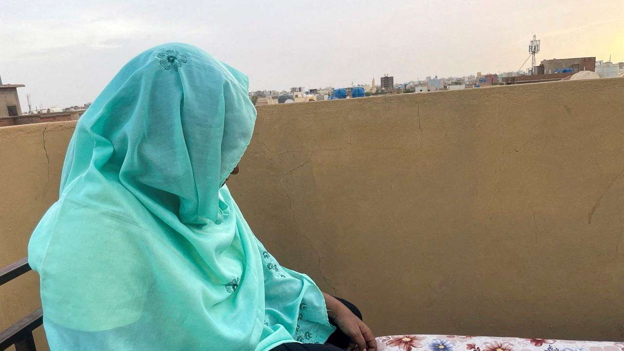 FILE PHOTO: Heba checks her phone for news of her relatives at her house during the conflict in Khartoum