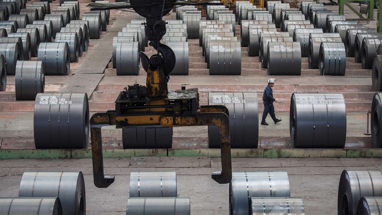 Worker walks past steel rolls at the Chongqing Iron and Steel plant in Changshou