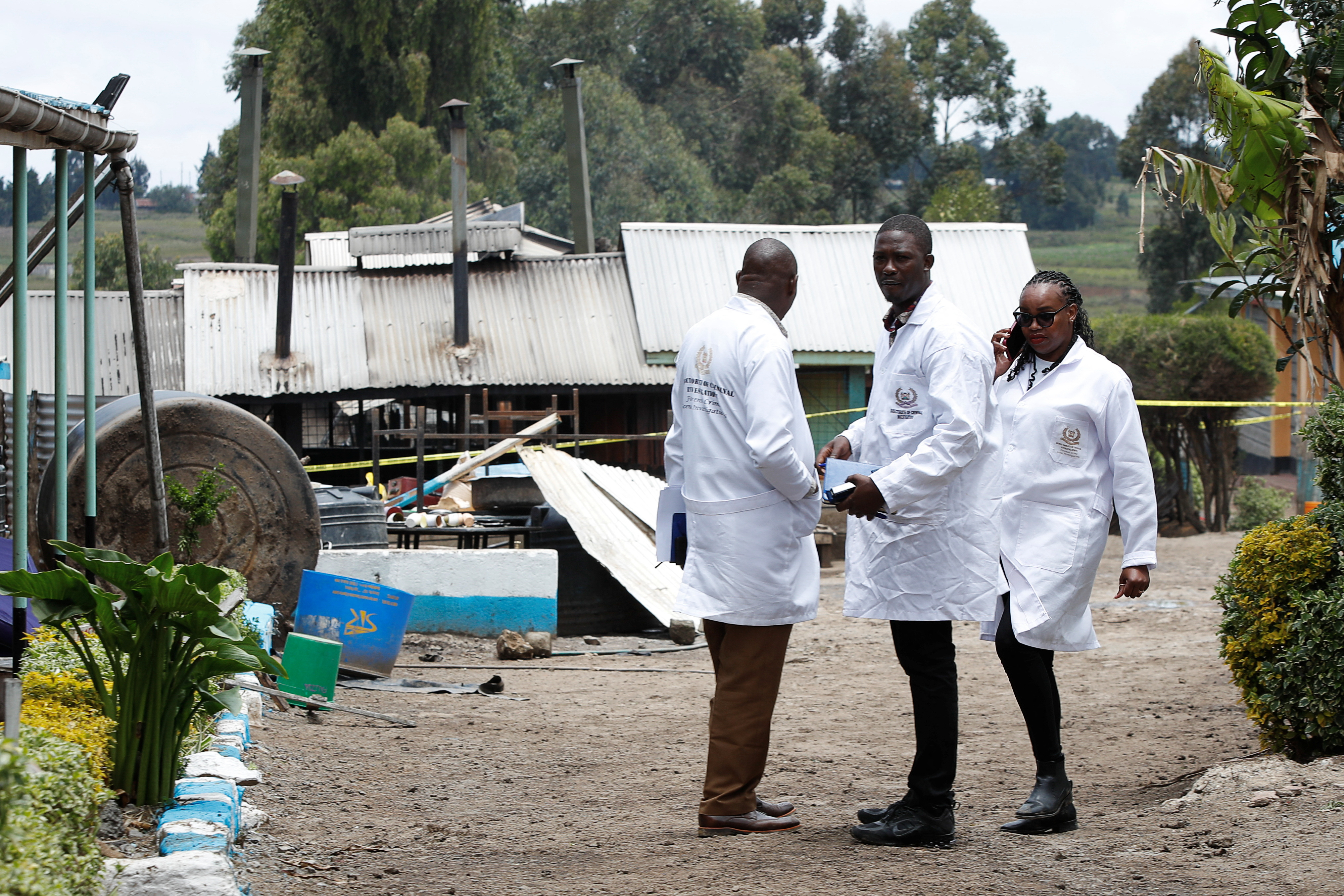 People gather outside the Hillside Endarasha Academy, after fatal fire, in Kieni