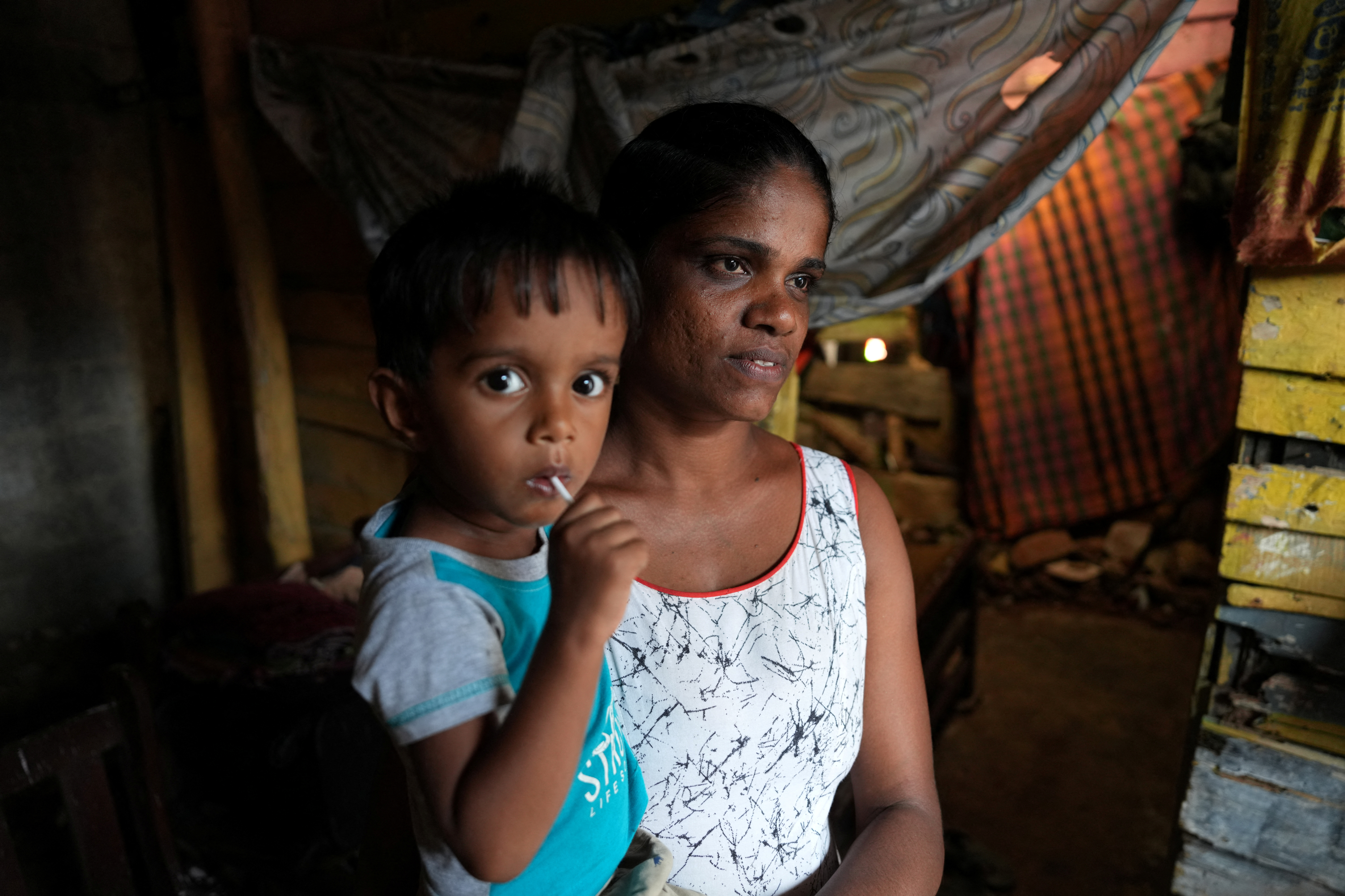 Lankika Dilrukshi along with her son is pictured inside her house in Thotalanga, Colombo