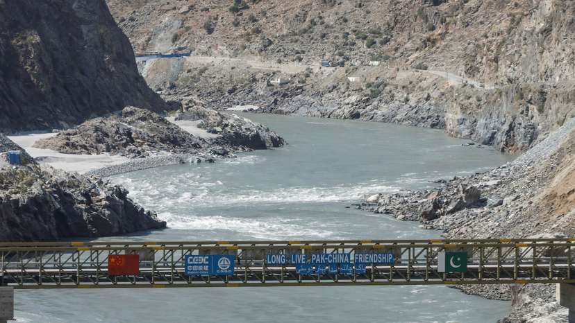FILE PHOTO: View of a bridge with China and Pakitan's flag over the River Indus near the site of the Dasu Dam, near Dasu