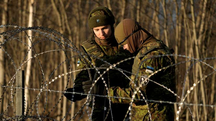 FILE PHOTO: Estonian army reservists build a fence on a border with Russia near Meremae