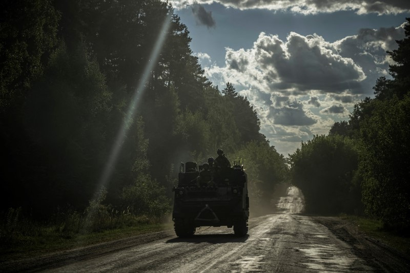 Ukrainian servicemen ride a military vehicle near the Russian border in Sumy region