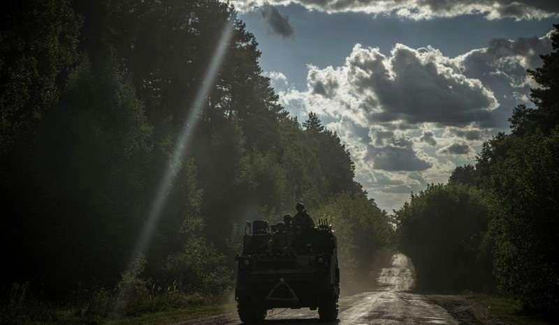 Ukrainian servicemen ride a military vehicle near the Russian border in Sumy region