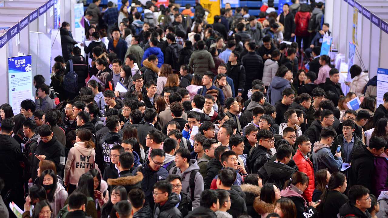 Students are seen at a job fair for graduates at a university in Shenyang, Liaoning