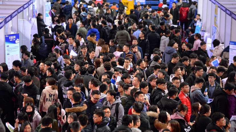 Students are seen at a job fair for graduates at a university in Shenyang, Liaoning