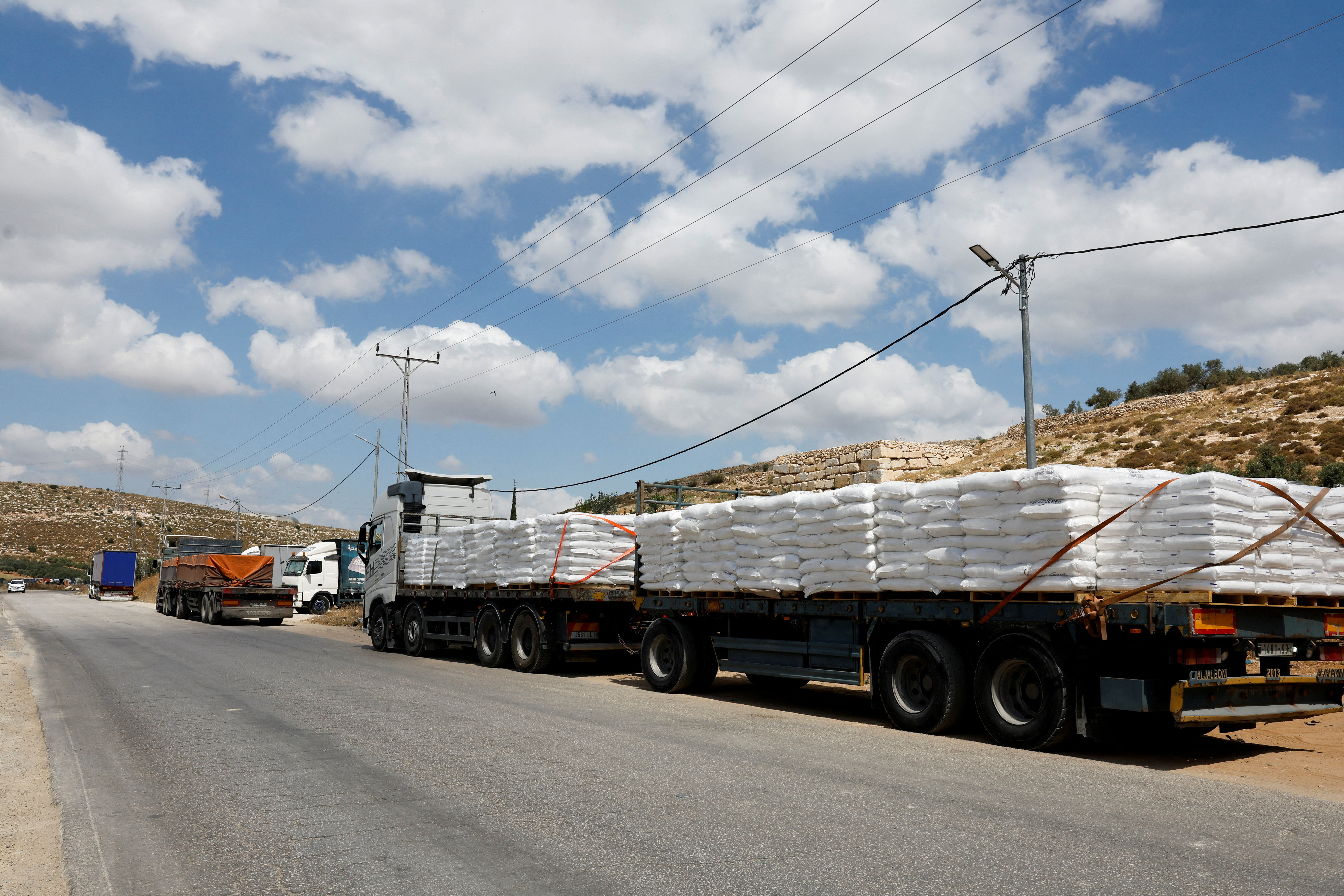 FILE PHOTO: Trucks carrying aid to Gaza stand damaged at checkpoint near Hebron