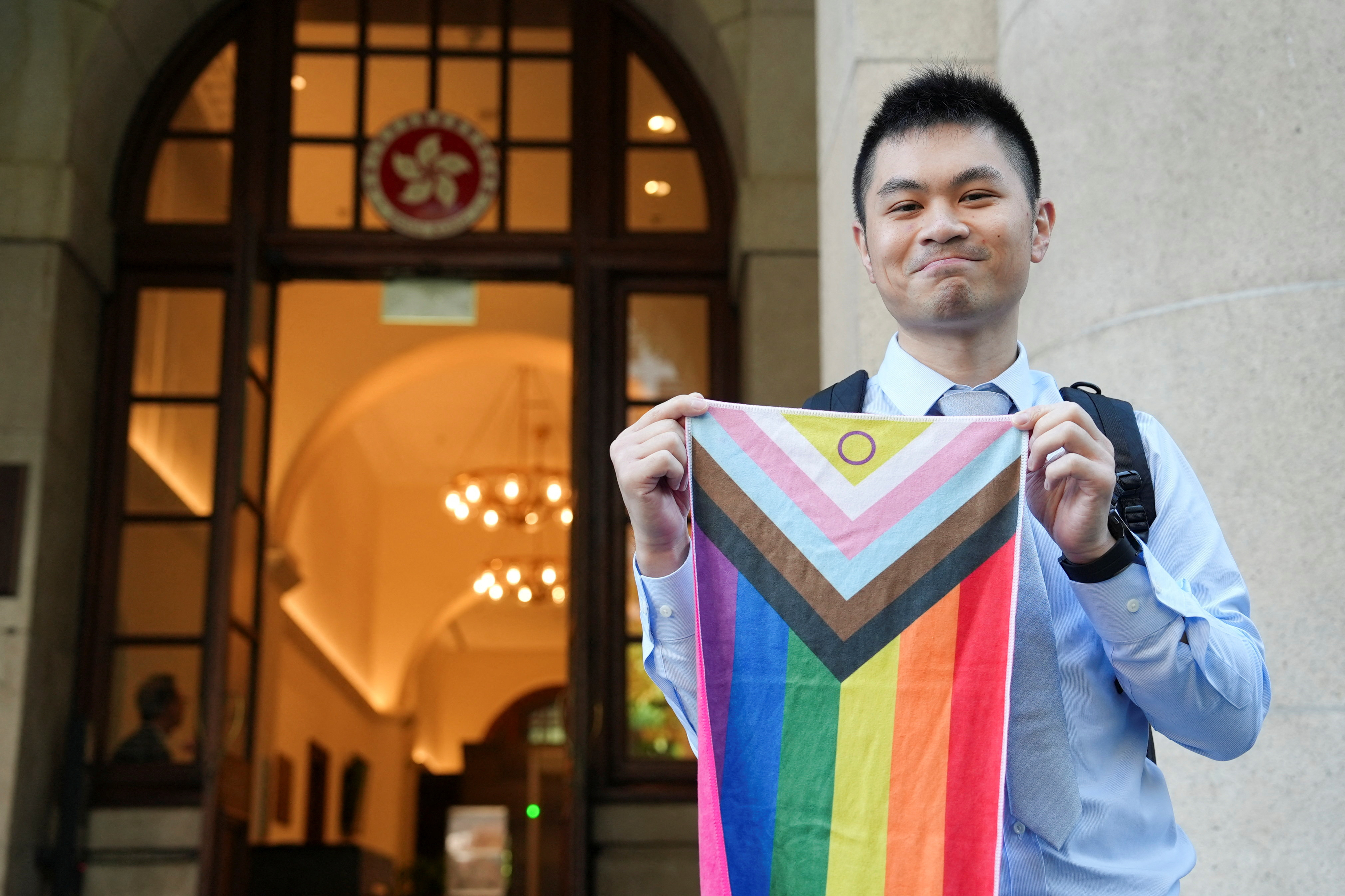 Nick Infinger holds intersex-inclusive pride progress flag after Hong Kong's top court rules in favour of equal housing and inheritance rights for same-sex couples in Hong Kong