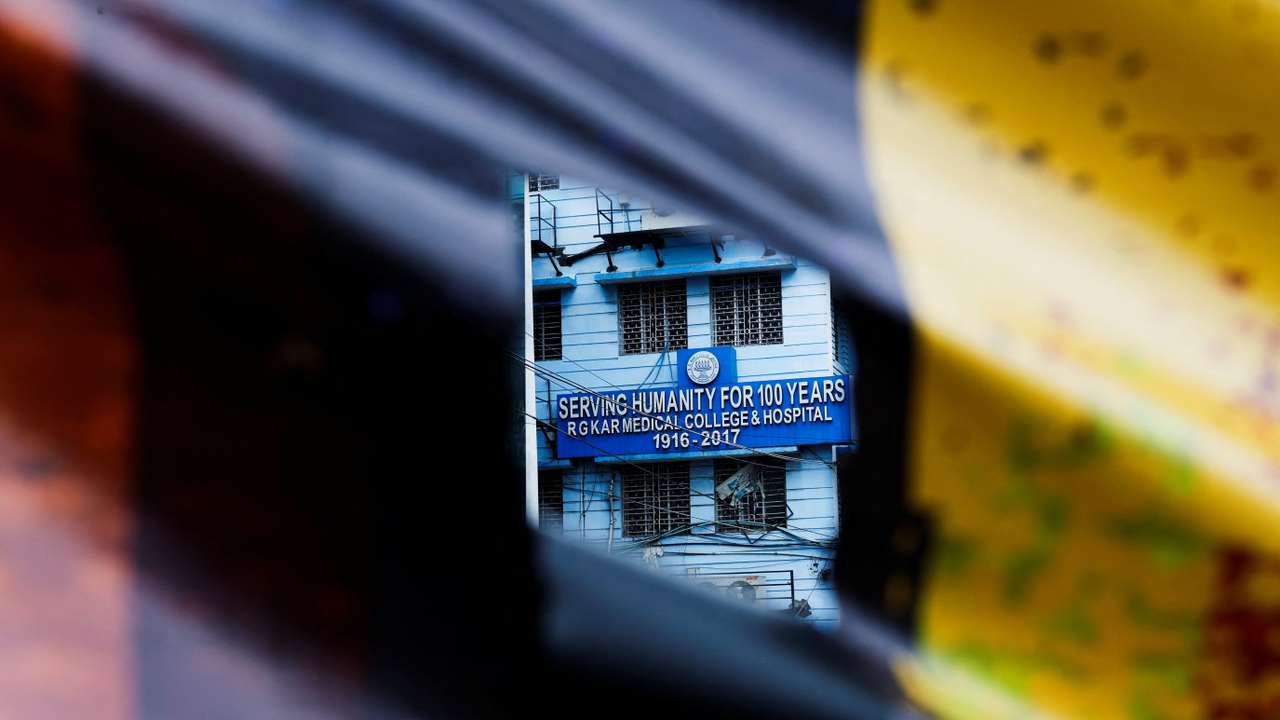 A signboard of R G Kar Medical College and Hospital is seen through a poster hanging on a closed gate, in Kolkata