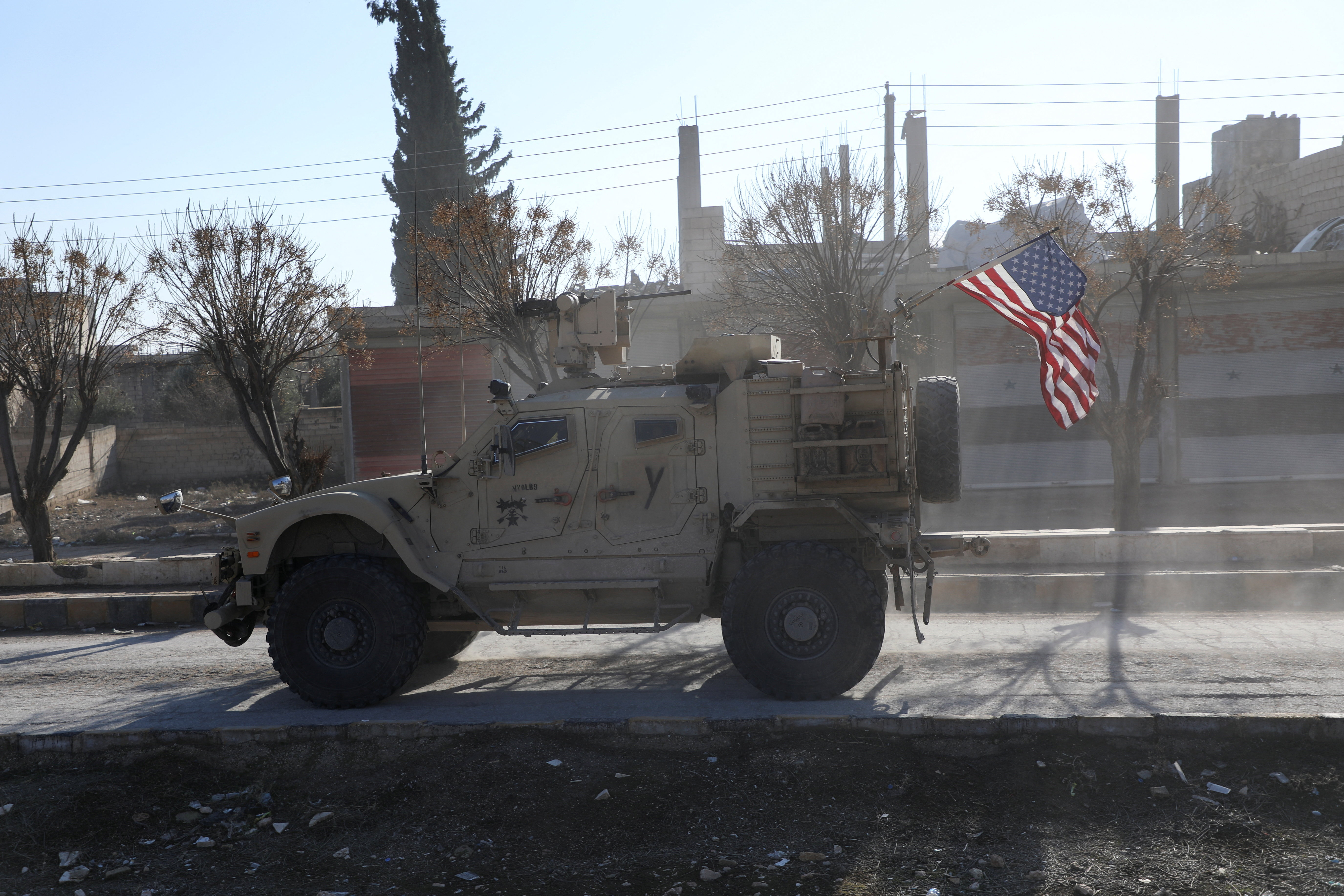 A U.S. military vehicle moves on a road on the day of a meeting between the Syrian Democratic Forces (SDF) leaders and U.S. military leaders, in Deir Hafer