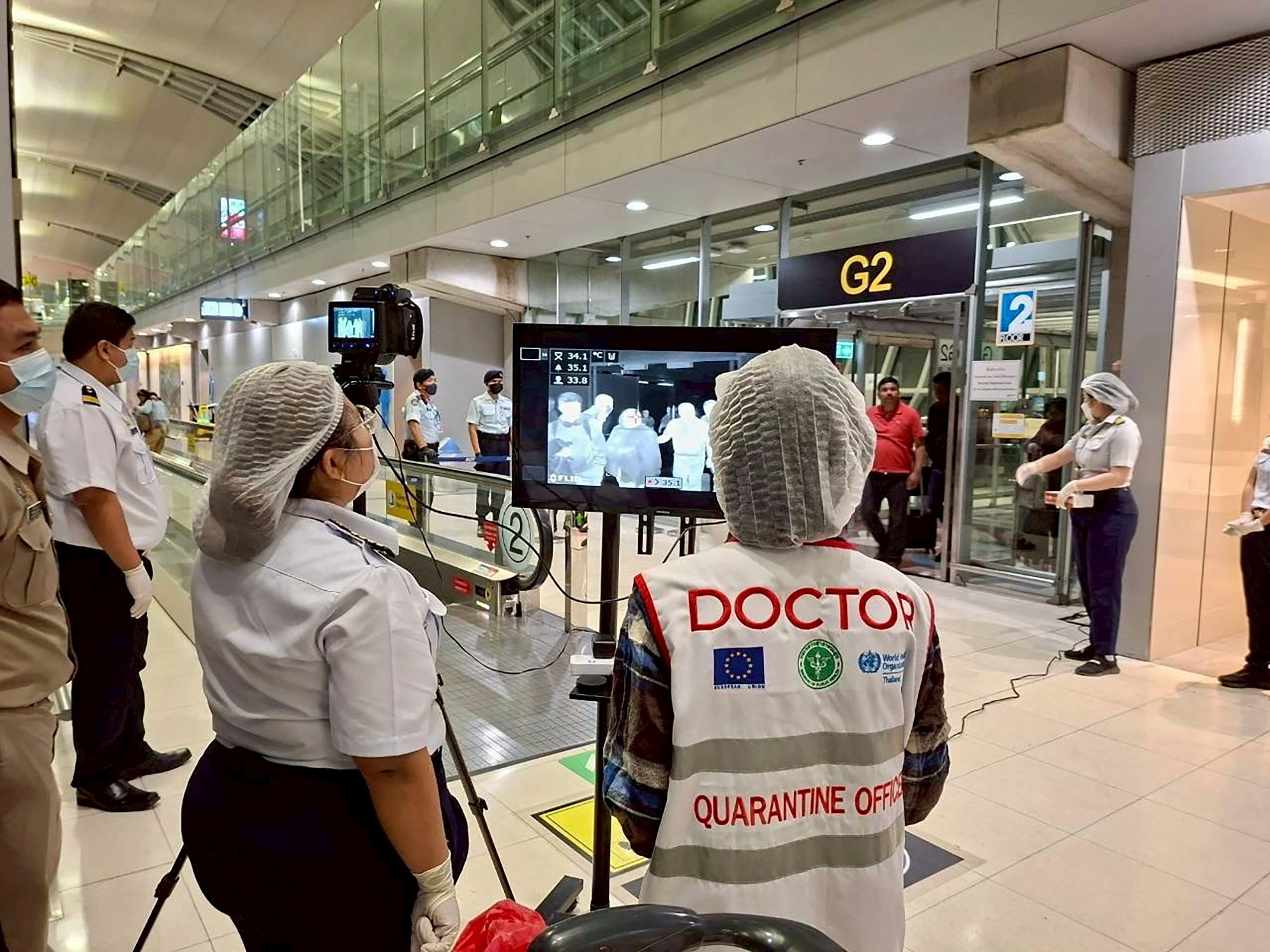 Airport health authorities wearing protective masks monitor passengers from international flights arriving at Suvarnabhumi International Airport