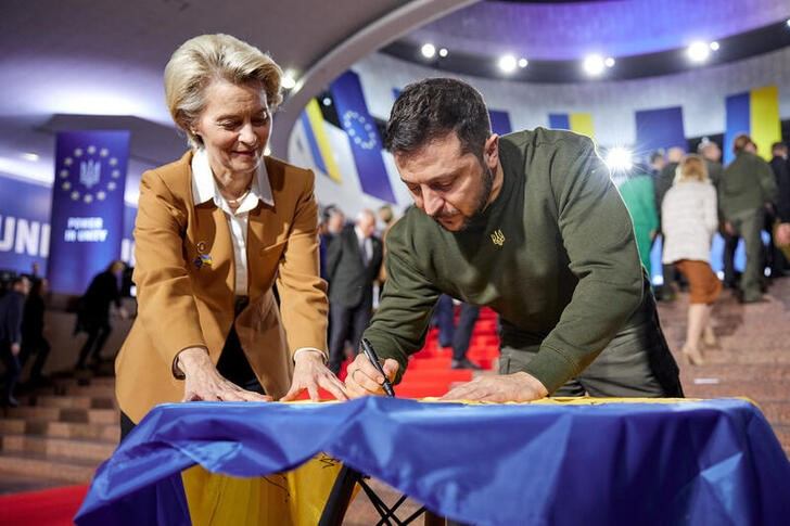 FILE PHOTO: Ukraine's President Zelenskiy and European Commission President von der Leyen sign a Ukrainian national flag before start of EU summit in Kyiv