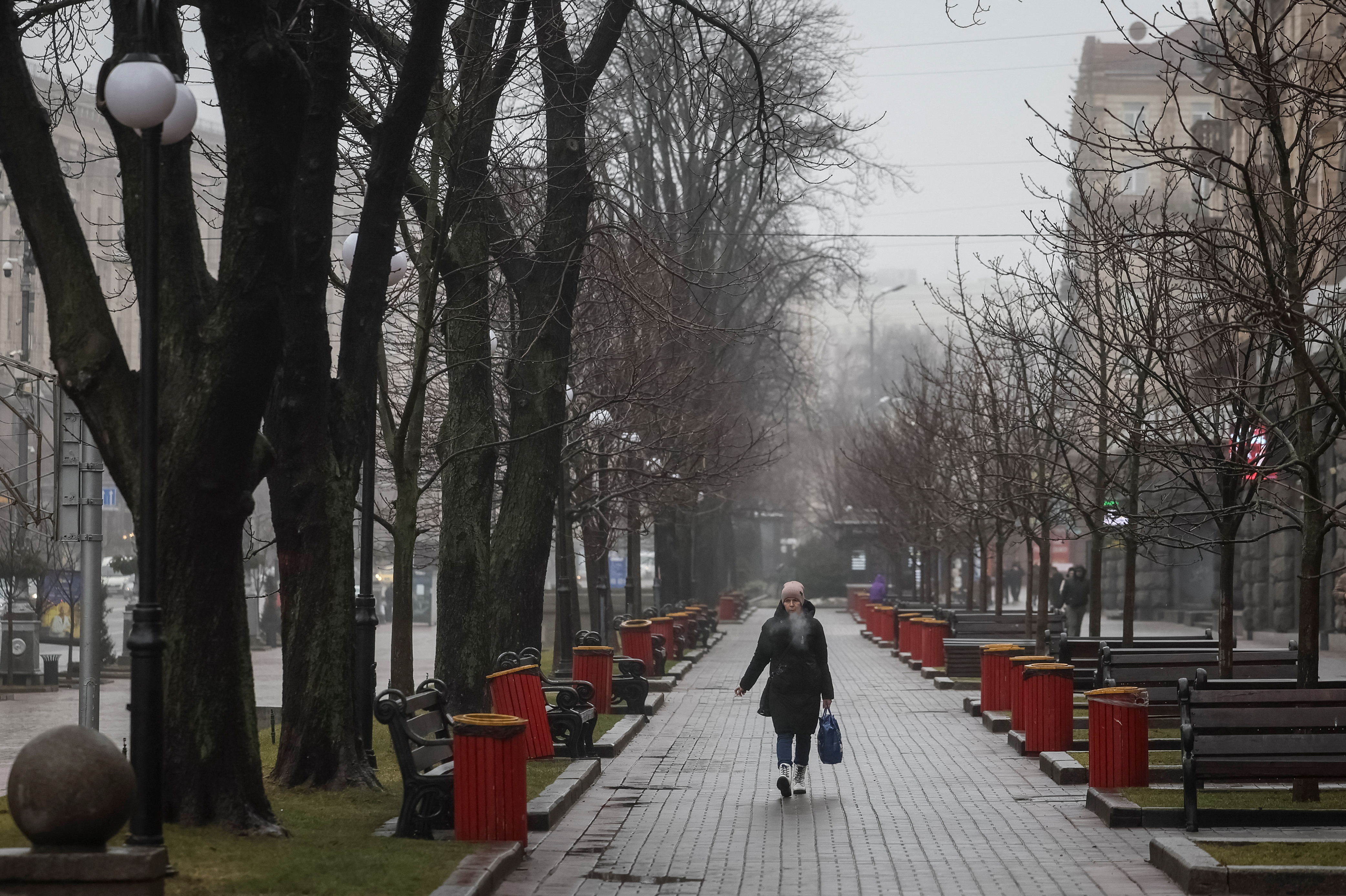 A woman smokes as she walks on the main street Khreshchatyk in central Kyiv
