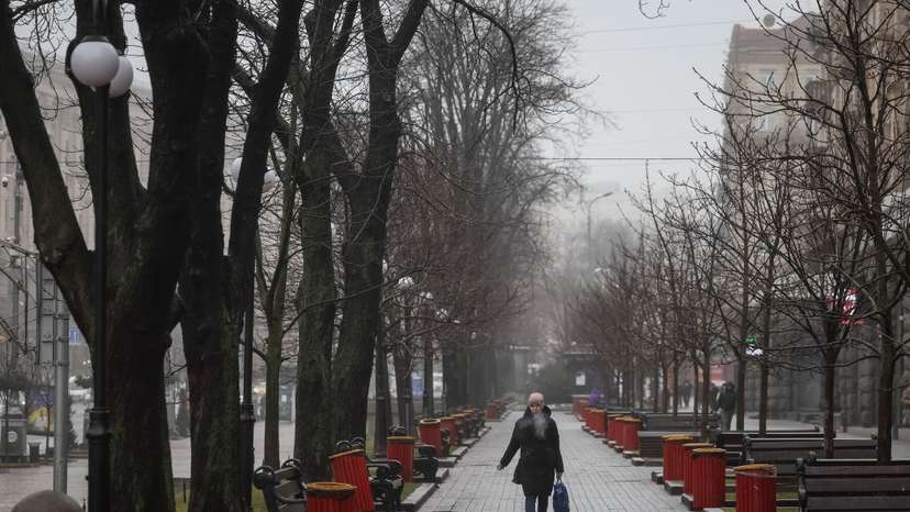 A woman smokes as she walks on the main street Khreshchatyk in central Kyiv
