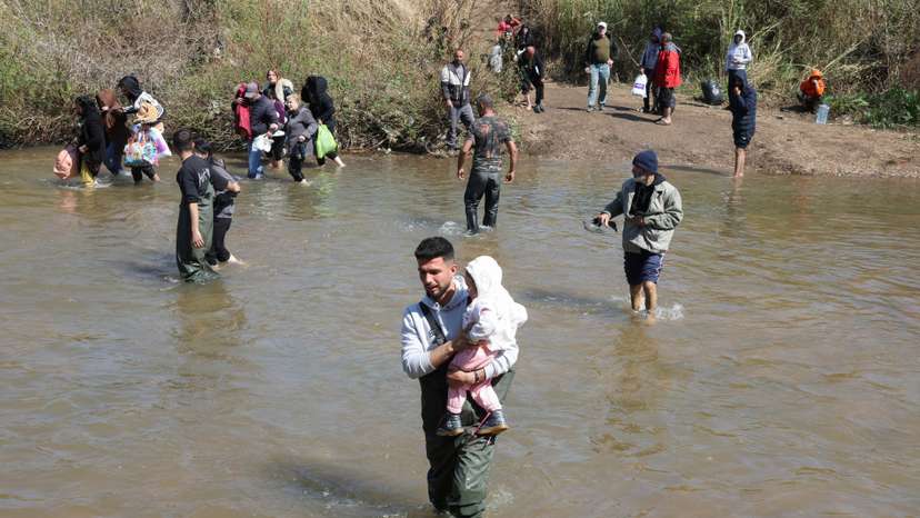 Alawite Syrians, who fled the violence in western Syria, walk in Nahr El Kabir River, in Akkar