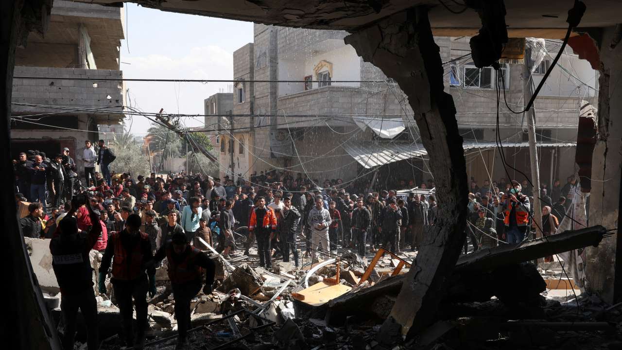 Palestinians inspect the site of an Israeli strike on a house, in Rafah