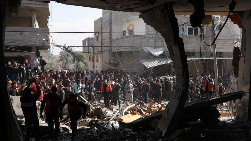 Palestinians inspect the site of an Israeli strike on a house, in Rafah