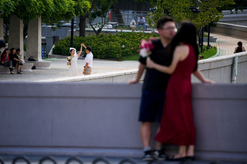 FILE PHOTO: Couples prepare to get their photo taken during a wedding photography shoot on a street, in Shanghai