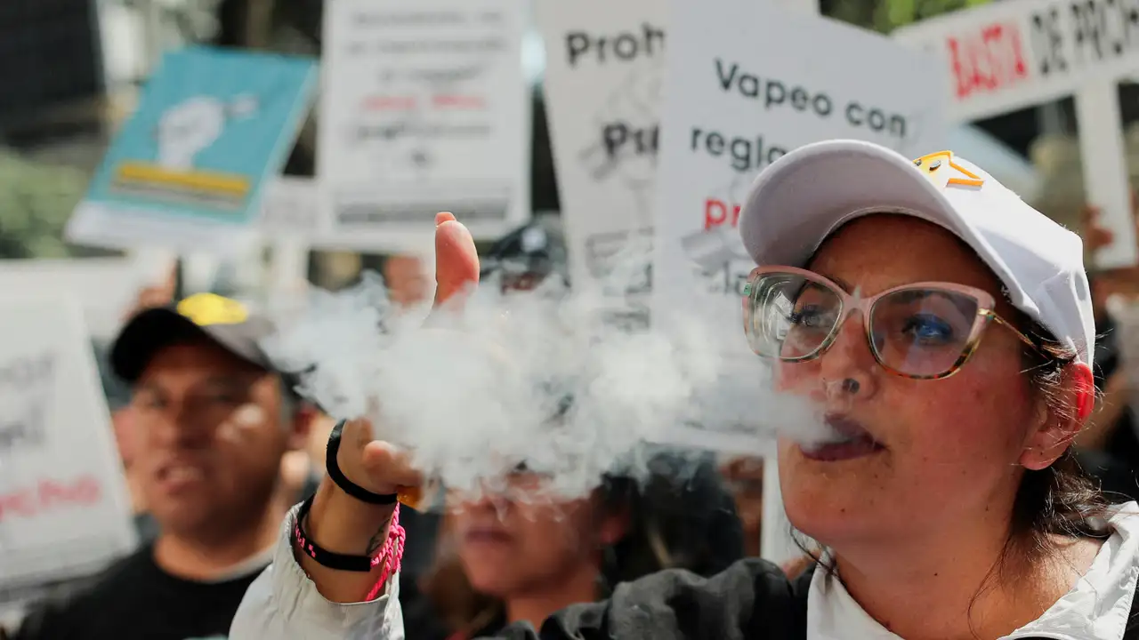 FILE PHOTO: A woman vapes during a protest outside the Senate after Mexican lower house lawmakers passed a proposal to alter the constitution to include a ban on e-cigarettes and vaping devices, in Mexico City, Mexico December 10, 2024. REUTERS/Henry Romero/File Photo