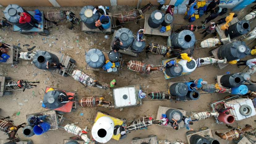 Palestinians with animal-drawn carts collect water from a water desalination plant, amid water shortages, in central Gaza Strip