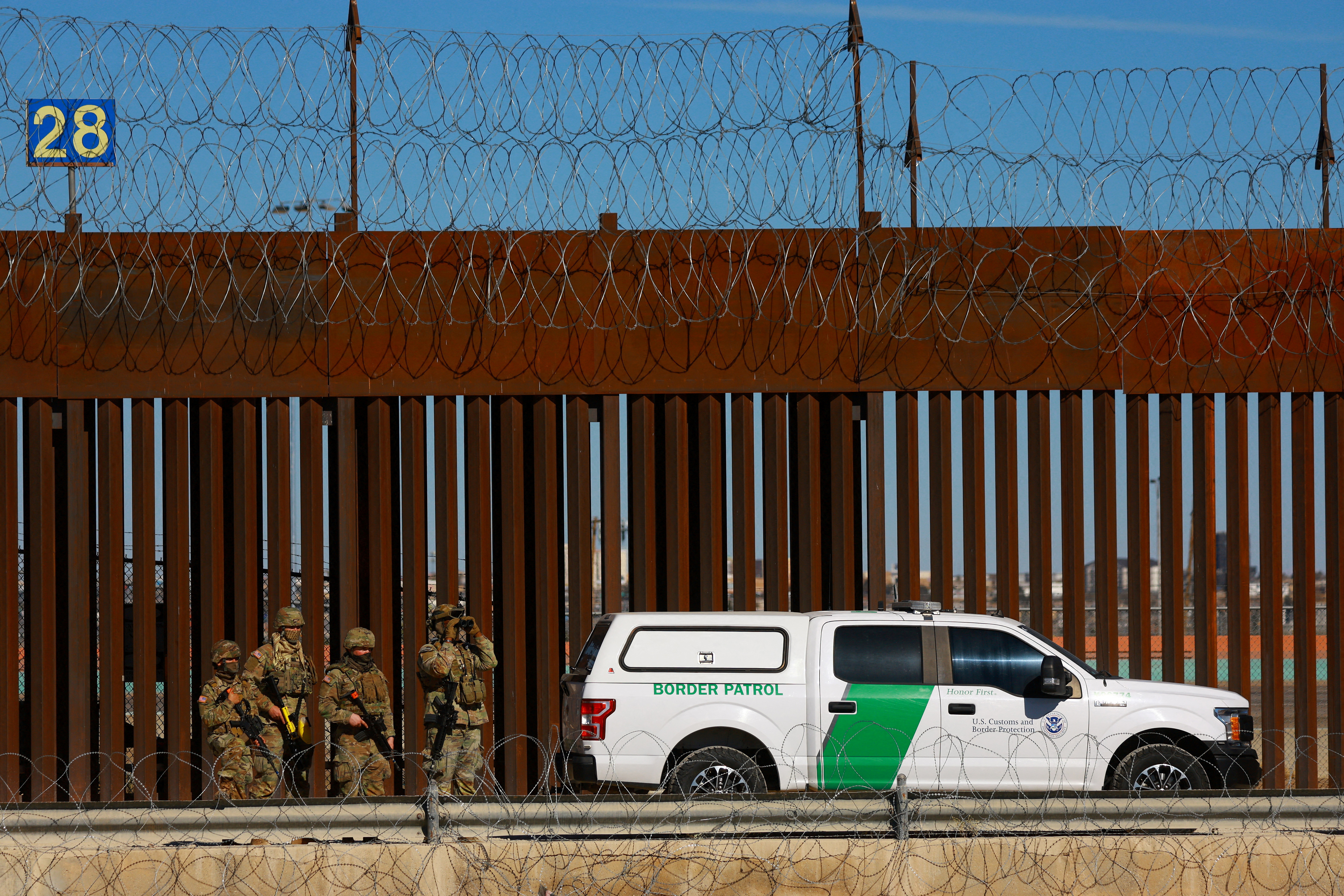 FILE PHOTO: Members of the Texas National Guard stand guard near the border wall between Mexico and the United States
