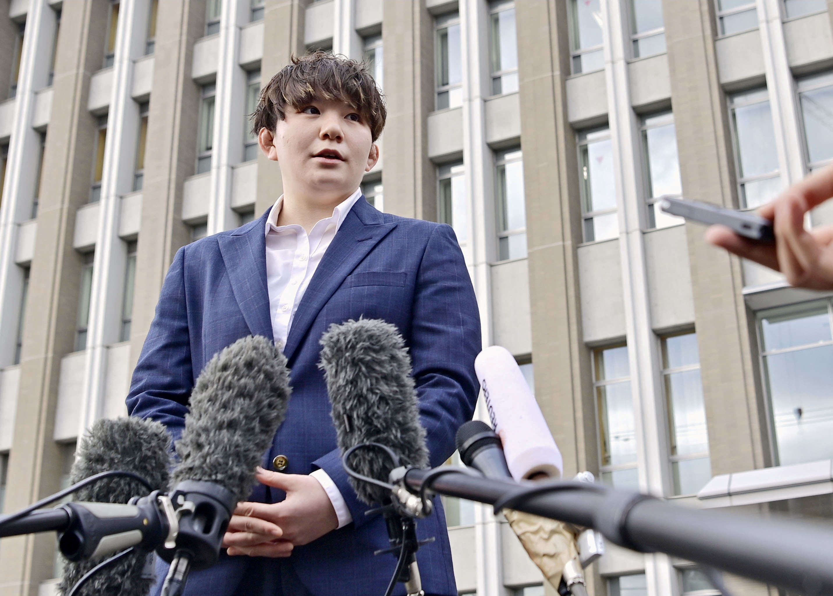 Rina Gonoi, a former member of Japan Self-Defense Forces, speaks to the media at the Fukushima District Court, in Fukushima