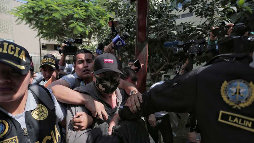 Police officers escort Nicanor Boluarte, brother of Peruvian President Dina Boluarte, in Lima