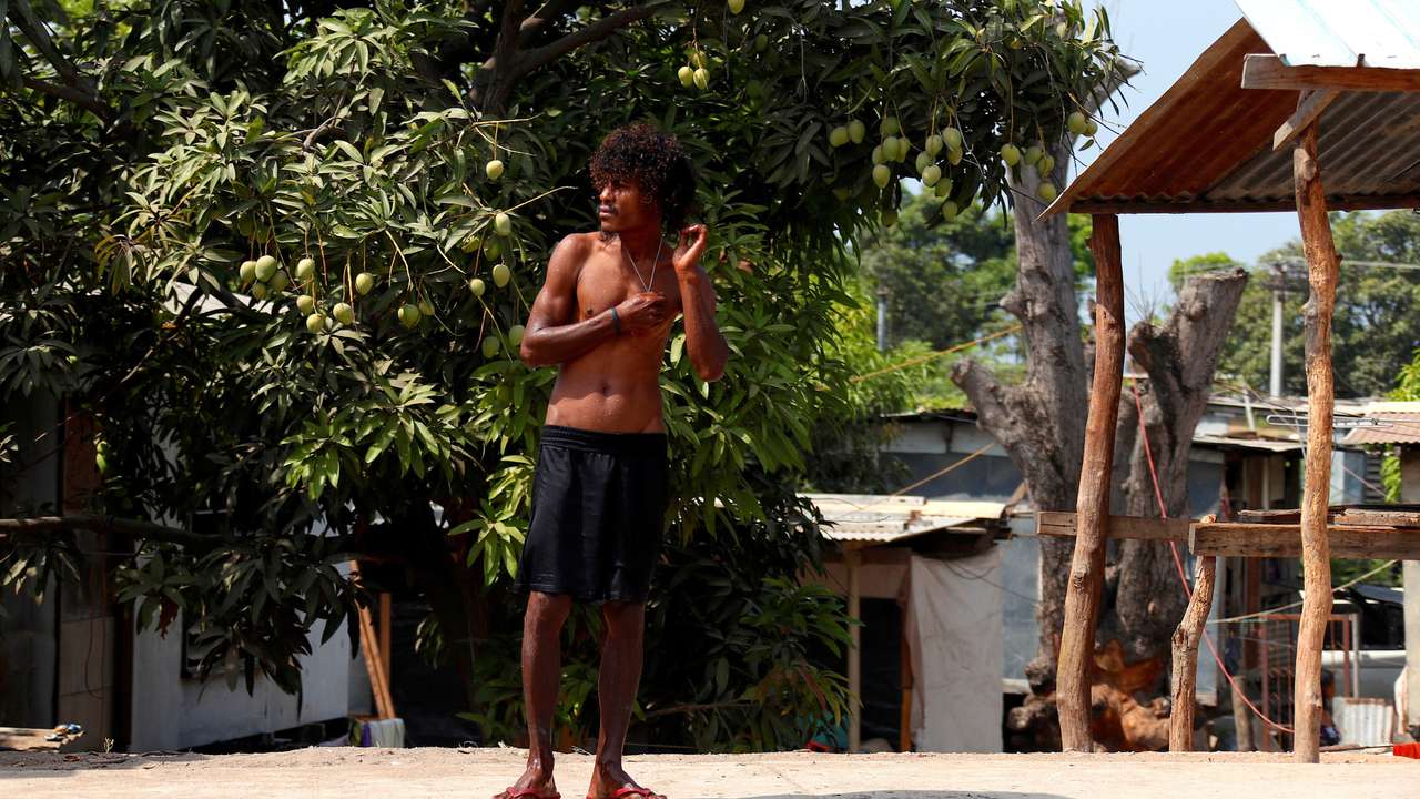 FILE PHOTO: A resident waits for a bus as he stands on a footpath in the area called Poreporena Villages in the city of Port Moresby in Papua New Guinea