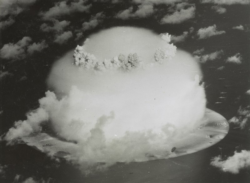 Handout of a mushroom cloud rises with ships below during Operation Crossroads nuclear weapons test on Bikini Atoll