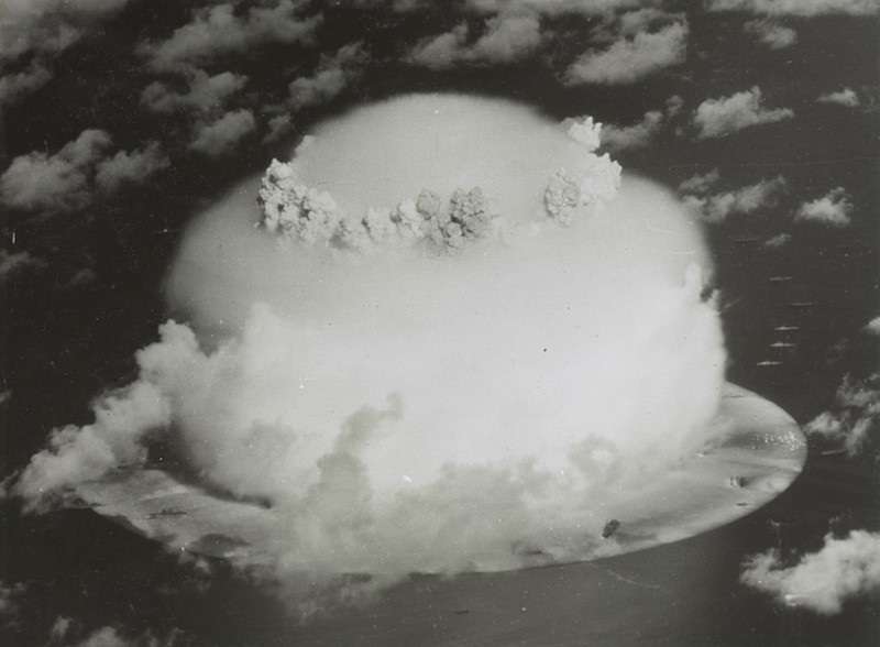 Handout of a mushroom cloud rises with ships below during Operation Crossroads nuclear weapons test on Bikini Atoll