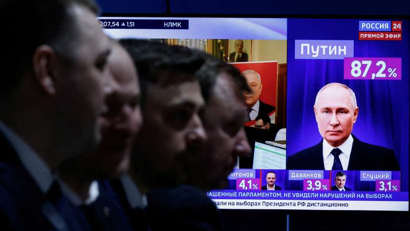 Men sit near a TV broadcasting news on the results of Russian incumbent President Putin, in Moscow