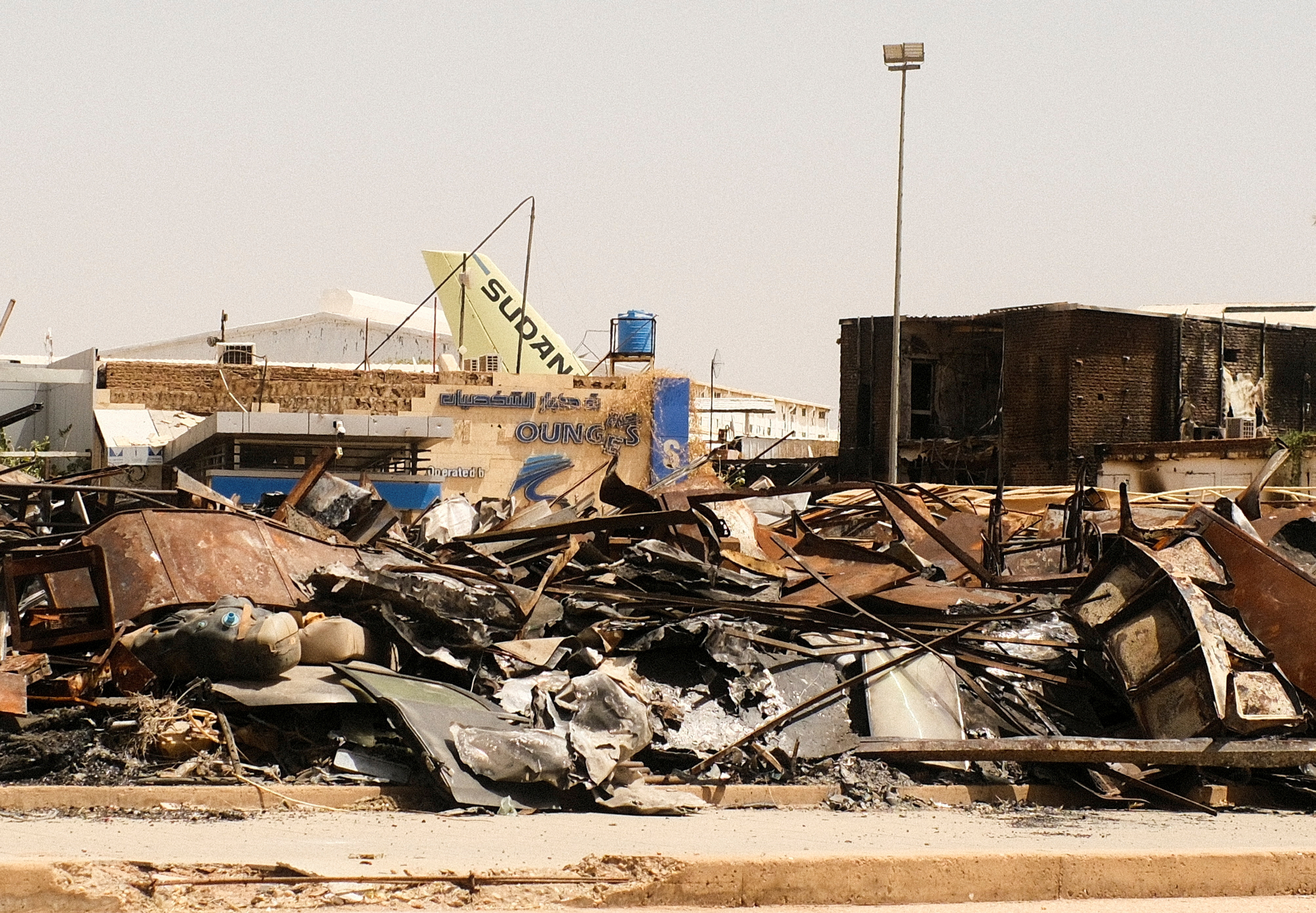 FILE PHOTO: A view of a burned building and the tail of a Sudan Airways aircraft amid debris at Khartoum Airport, in Khartoum