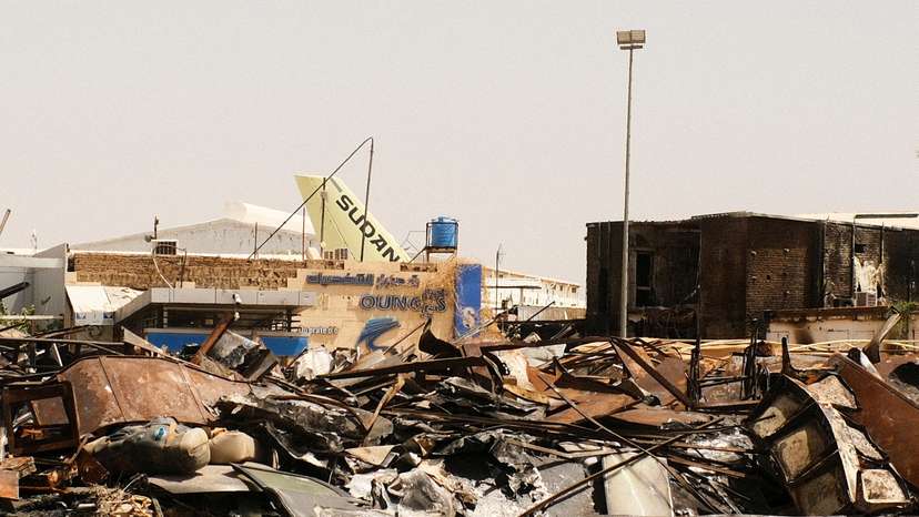 FILE PHOTO: A view of a burned building and the tail of a Sudan Airways aircraft amid debris at Khartoum Airport, in Khartoum