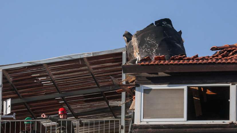People gather at the site where part of an Iranian missile landed, in East Jerusalem