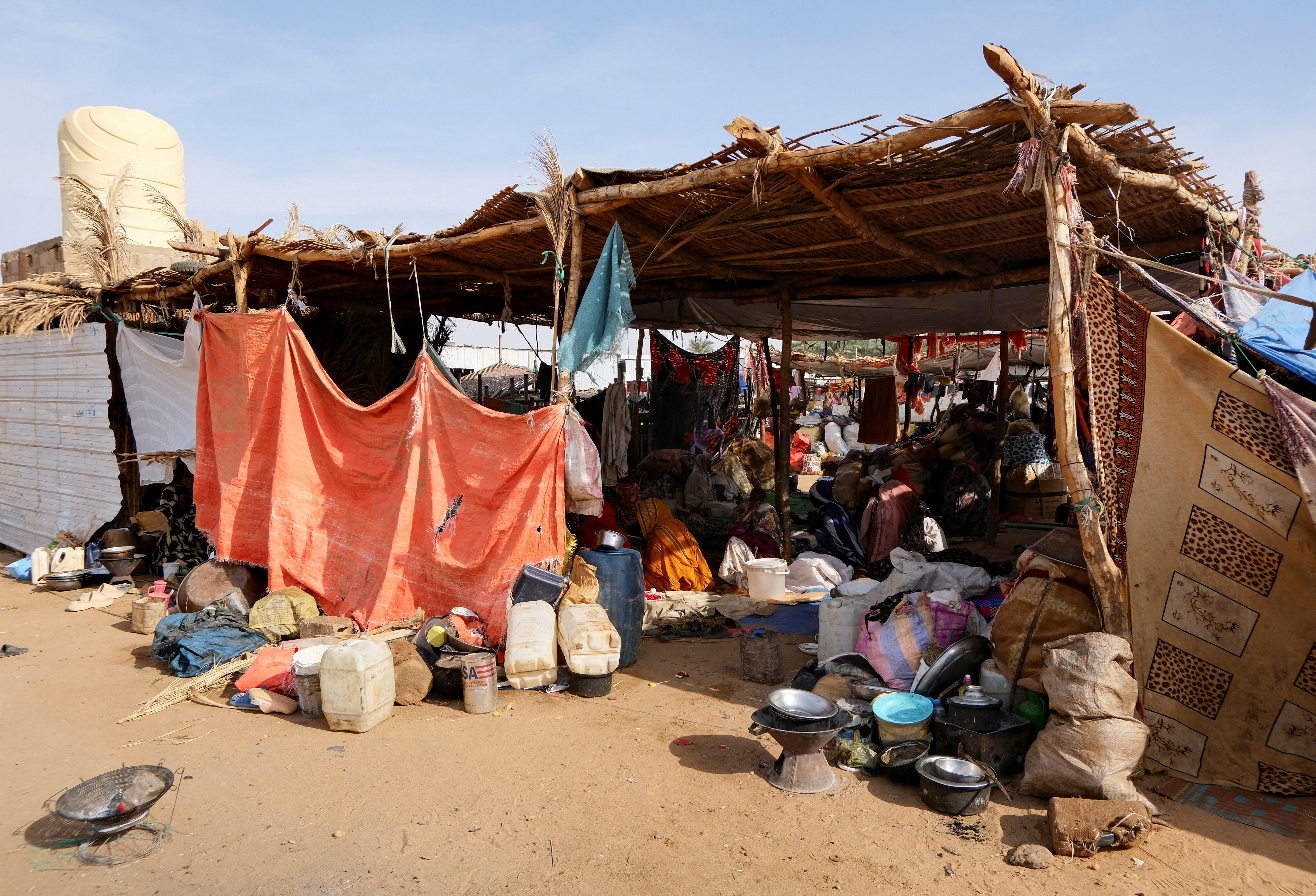 FILE PHOTO: Sudanese women who fled intense fighting in al-Fashir sit on the ground at a displacement camp, in Al Dabba