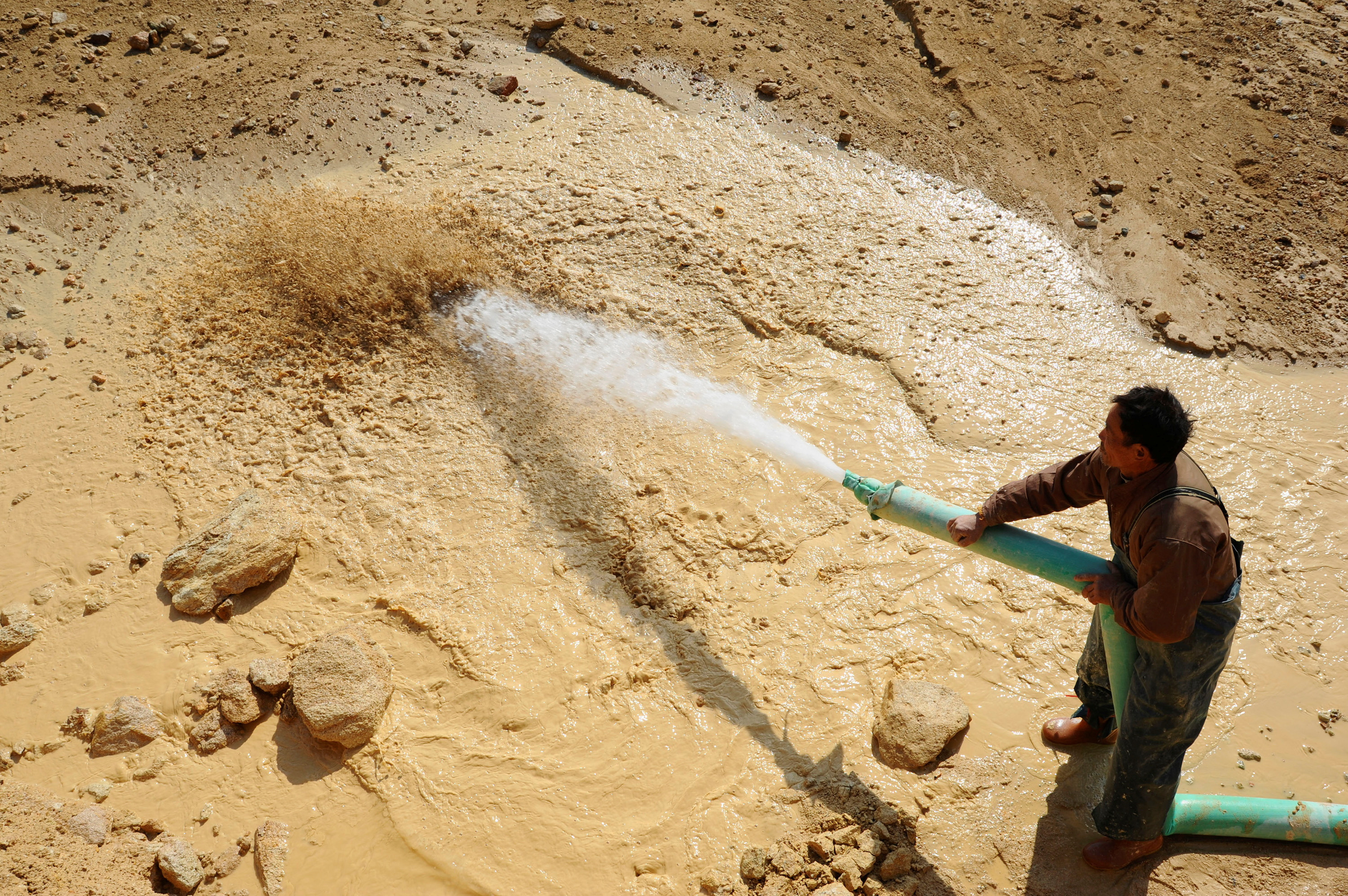FILE PHOTO: A worker waters the site of a rare earth metals mine at Nancheng county