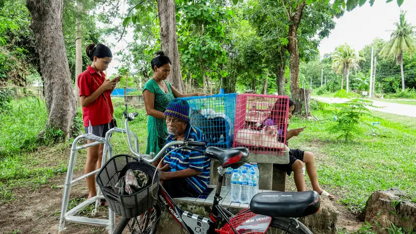 People rest at a shelter amid the clashes between Thailand and Cambodia