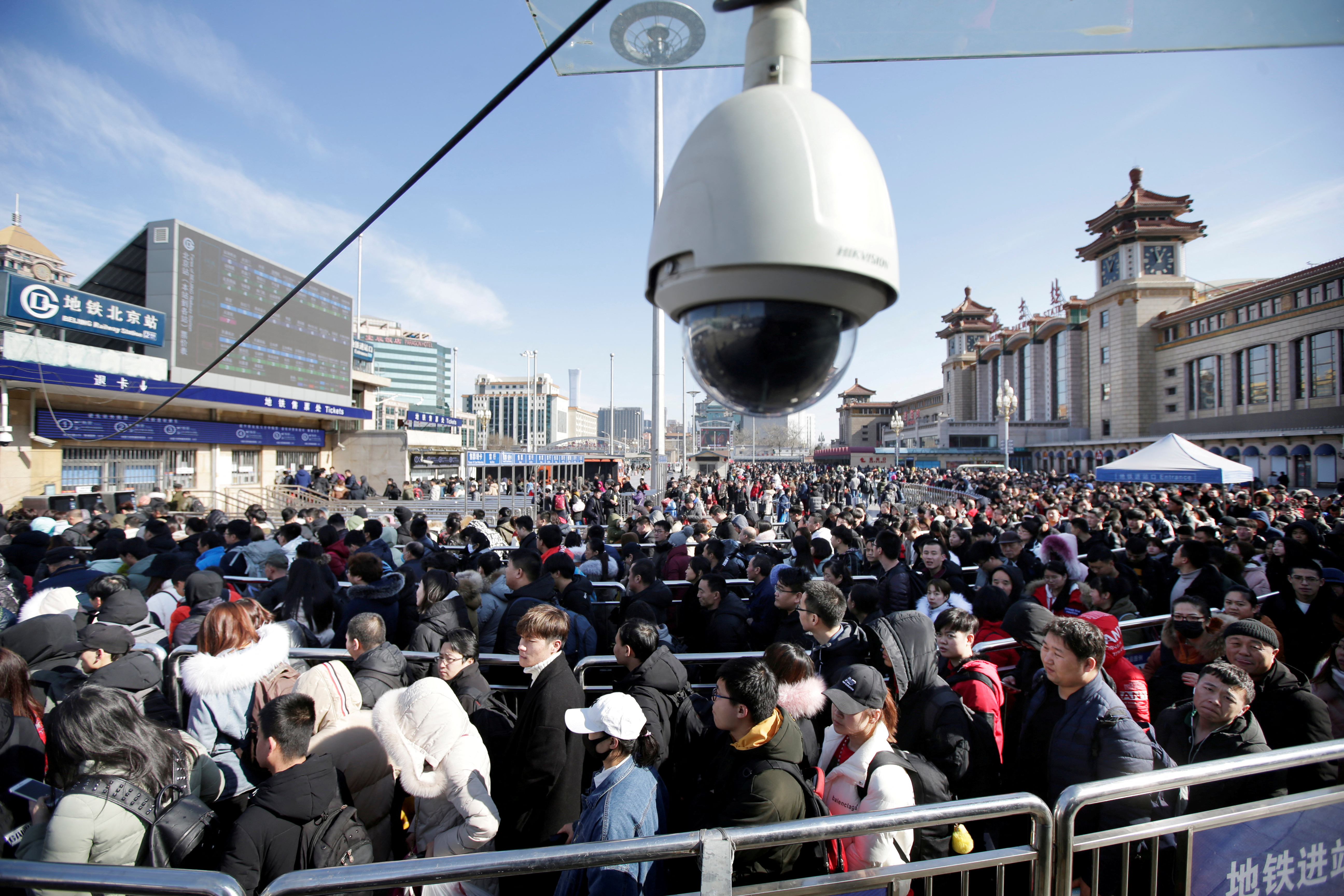FILE PHOTO: Passengers wait to enter a subway outside Beijing Railway Station as the annual Spring Festival holidays ended in Beijing in 2019