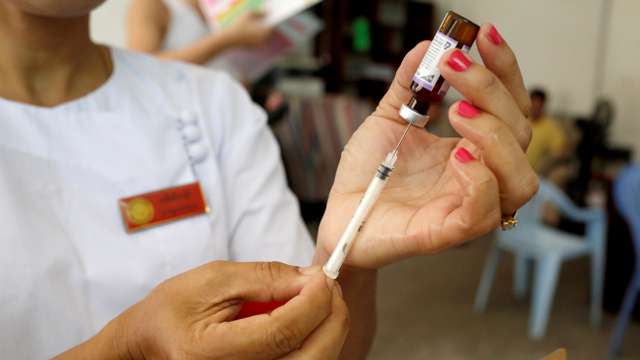 A nurse prepares a measles-rubella vaccine