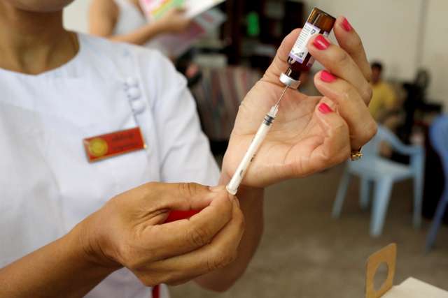 A nurse prepares a measles-rubella vaccine