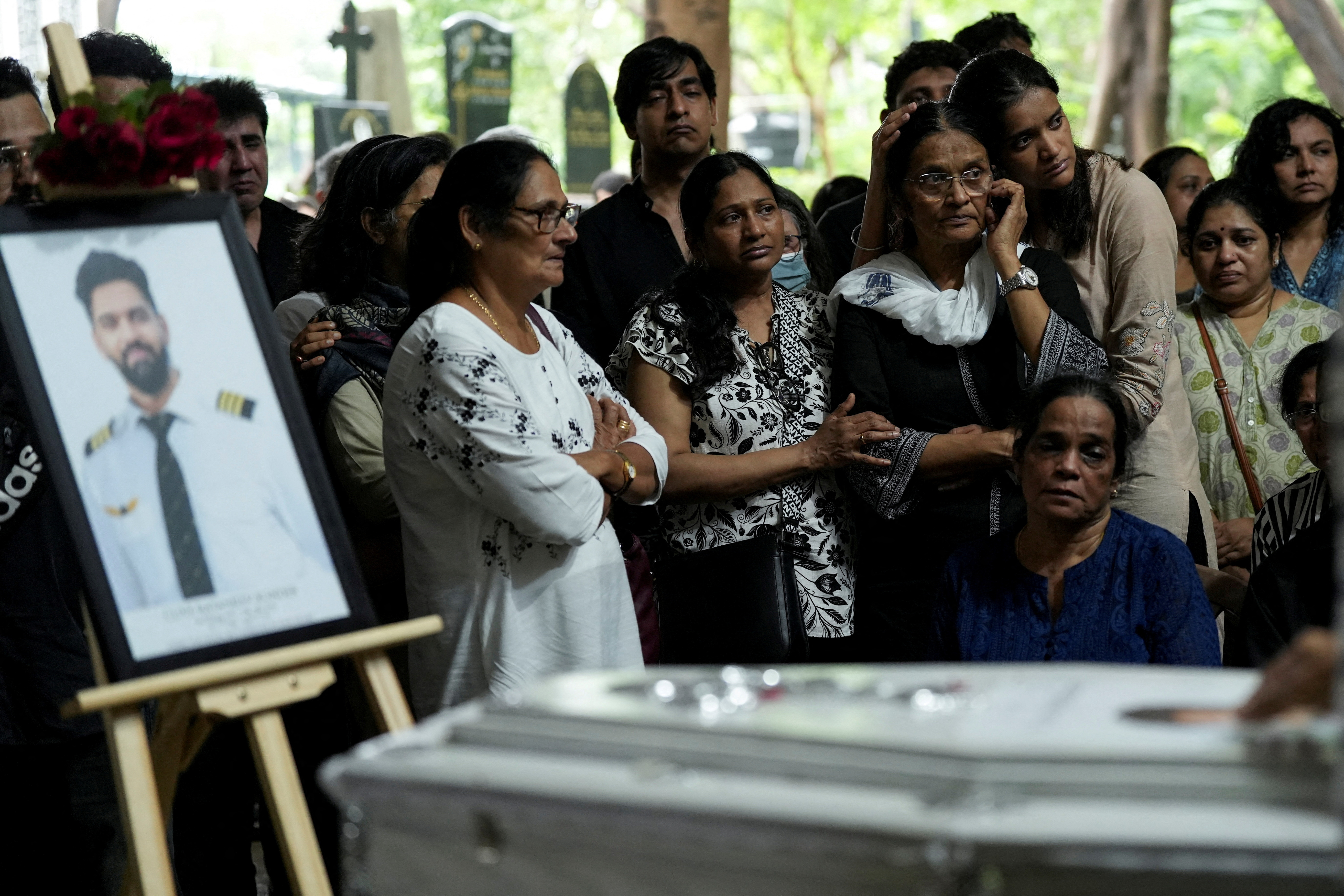 FILE PHOTO: Friends and family members mourn near the coffin of Co-Pilot Clive Kunder, who died after an AIR India Boeing 787-8 Dreamliner plane crashed during take-off from an airport in Ahmedabad, in Mumbai