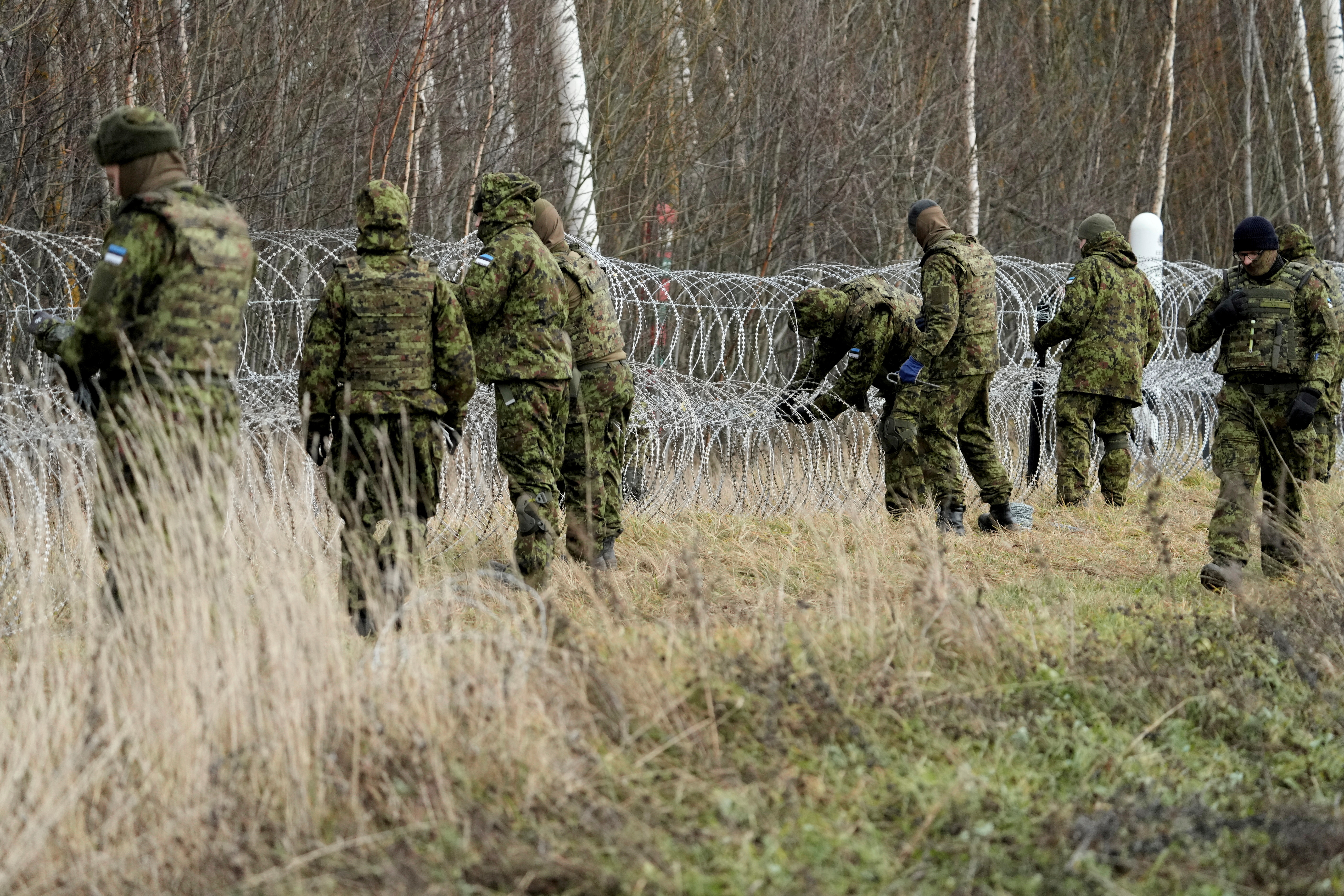 Estonian army reservists build a fence on a border with Russia near Meremae