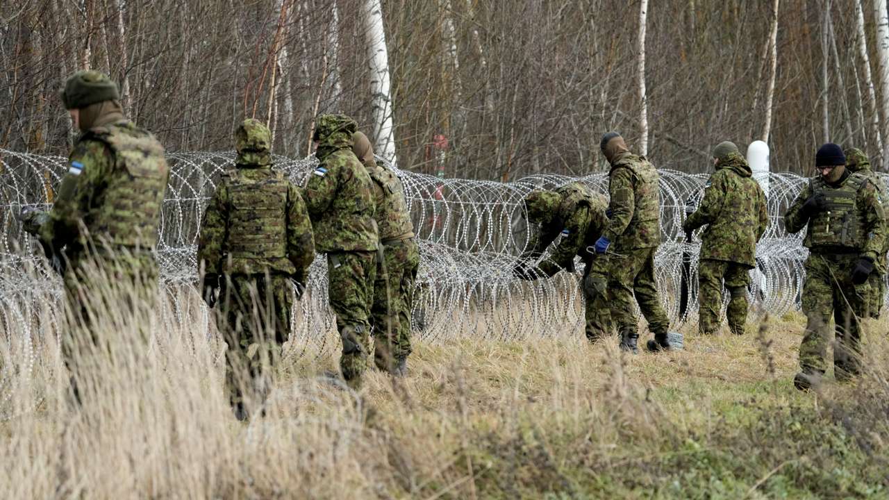 Estonian army reservists build a fence on a border with Russia near Meremae