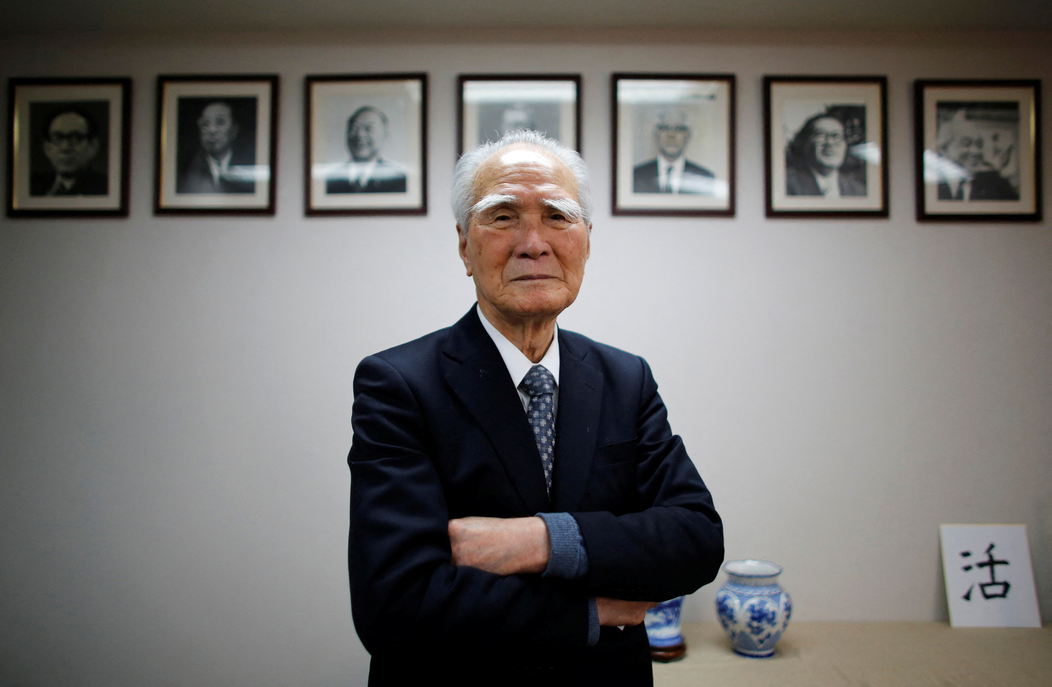 Former Japanese PM Murayama poses in front of portraits of former leaders of his Social Democratic Party after an interview with Reuters at the party headquarters in Tokyo